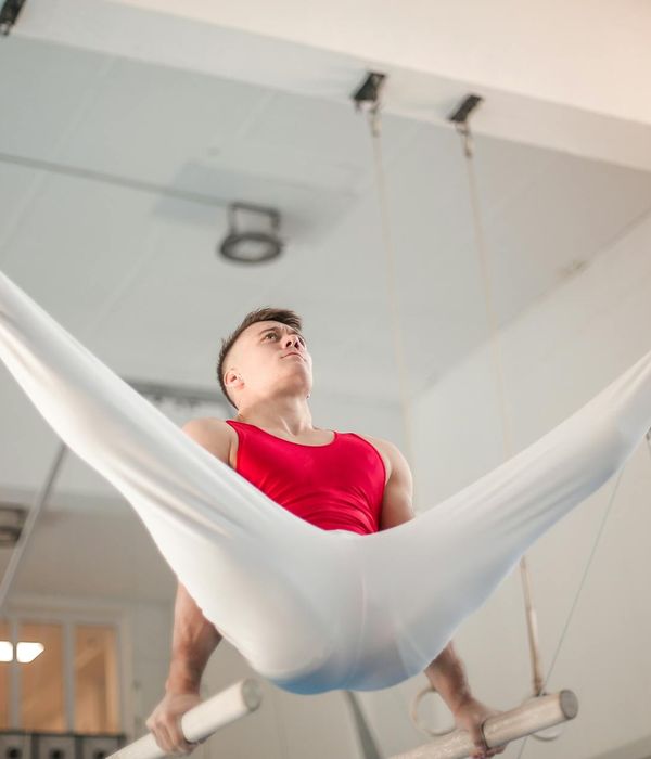 Man performing a controlled strength exercise in a dark, focused environment with purple ambient light.